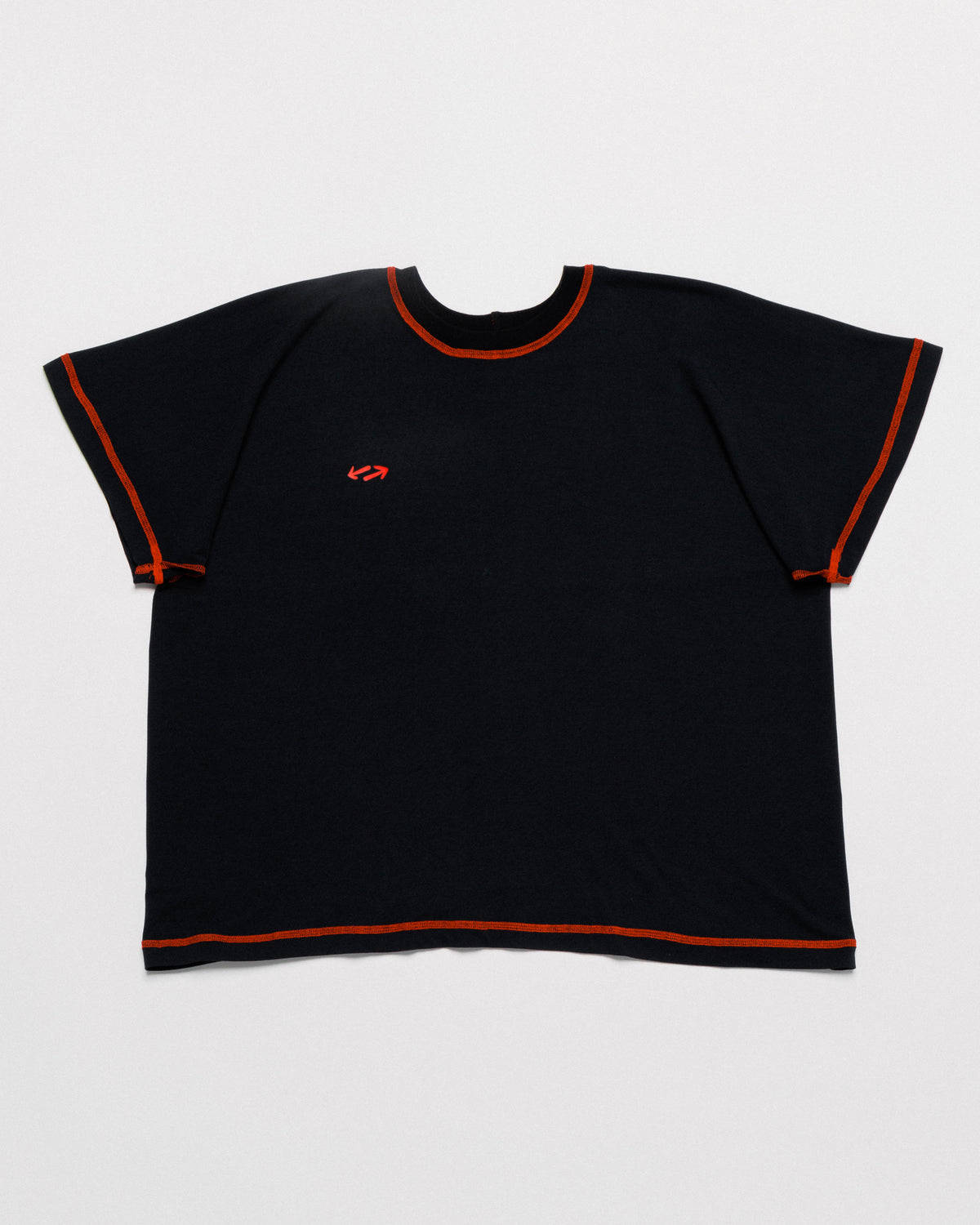 Outnback Bog Tee in black, front flat lay with contrast orange stitching and red arrow logo