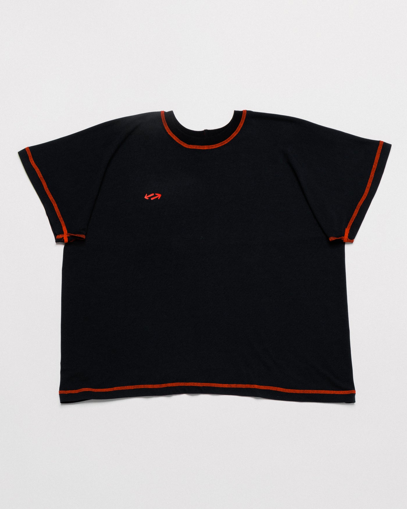 Outnback Bog Tee in black, front flat lay with contrast orange stitching and red arrow logo