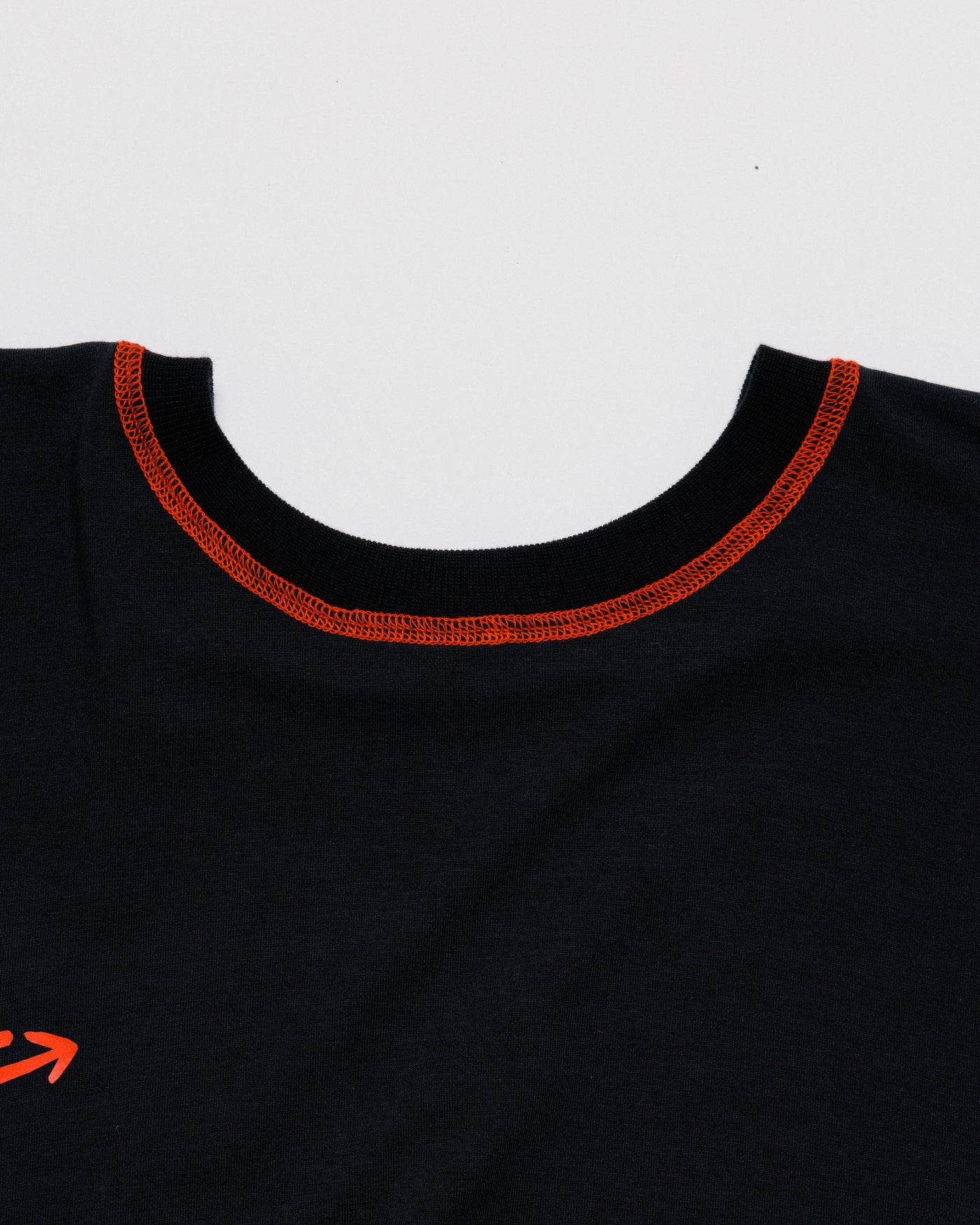 Outnback Bog Tee neckline detail showing orange overlock collar stitching