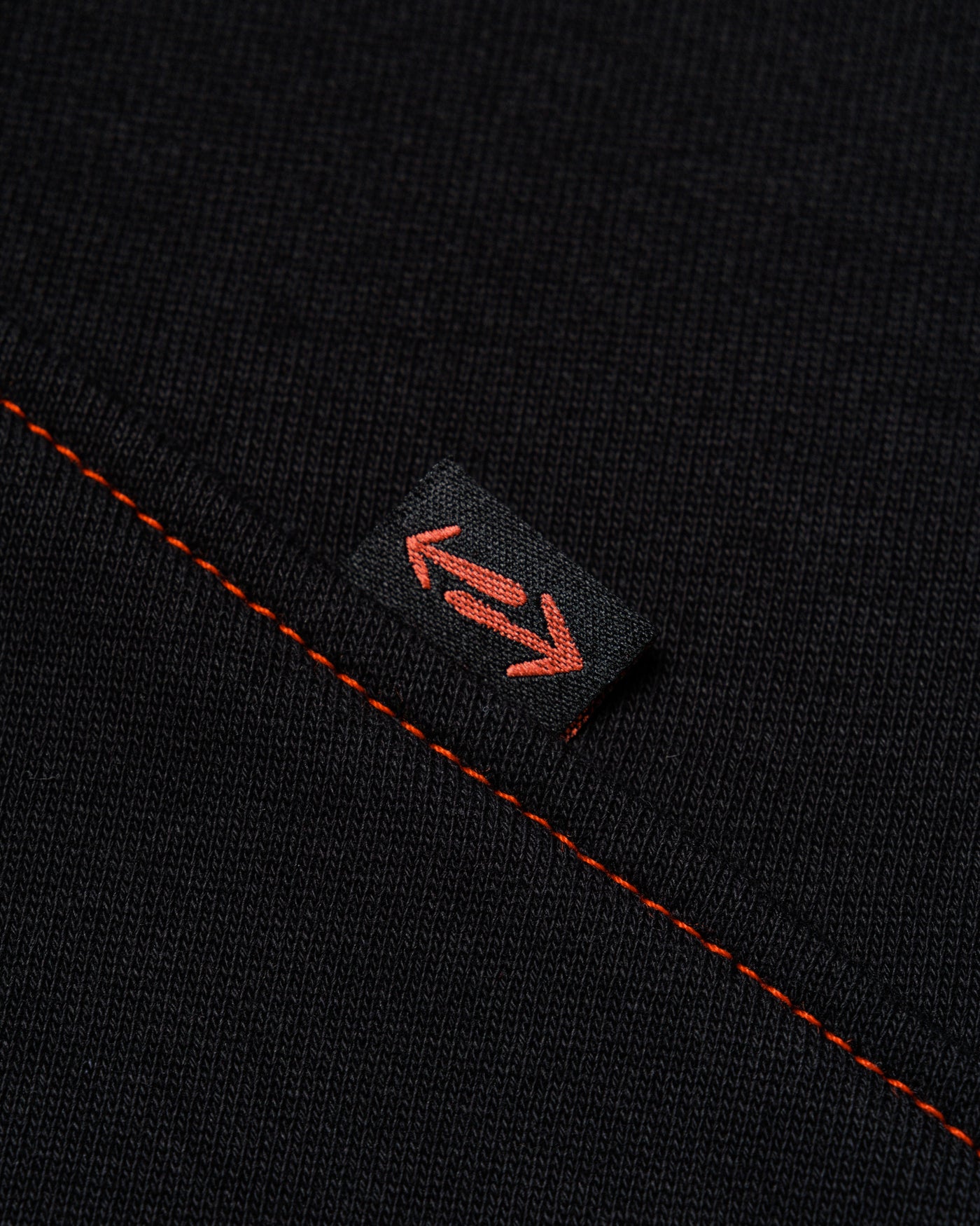 Outnback Recovery Cape in black, woven arrow tab detail