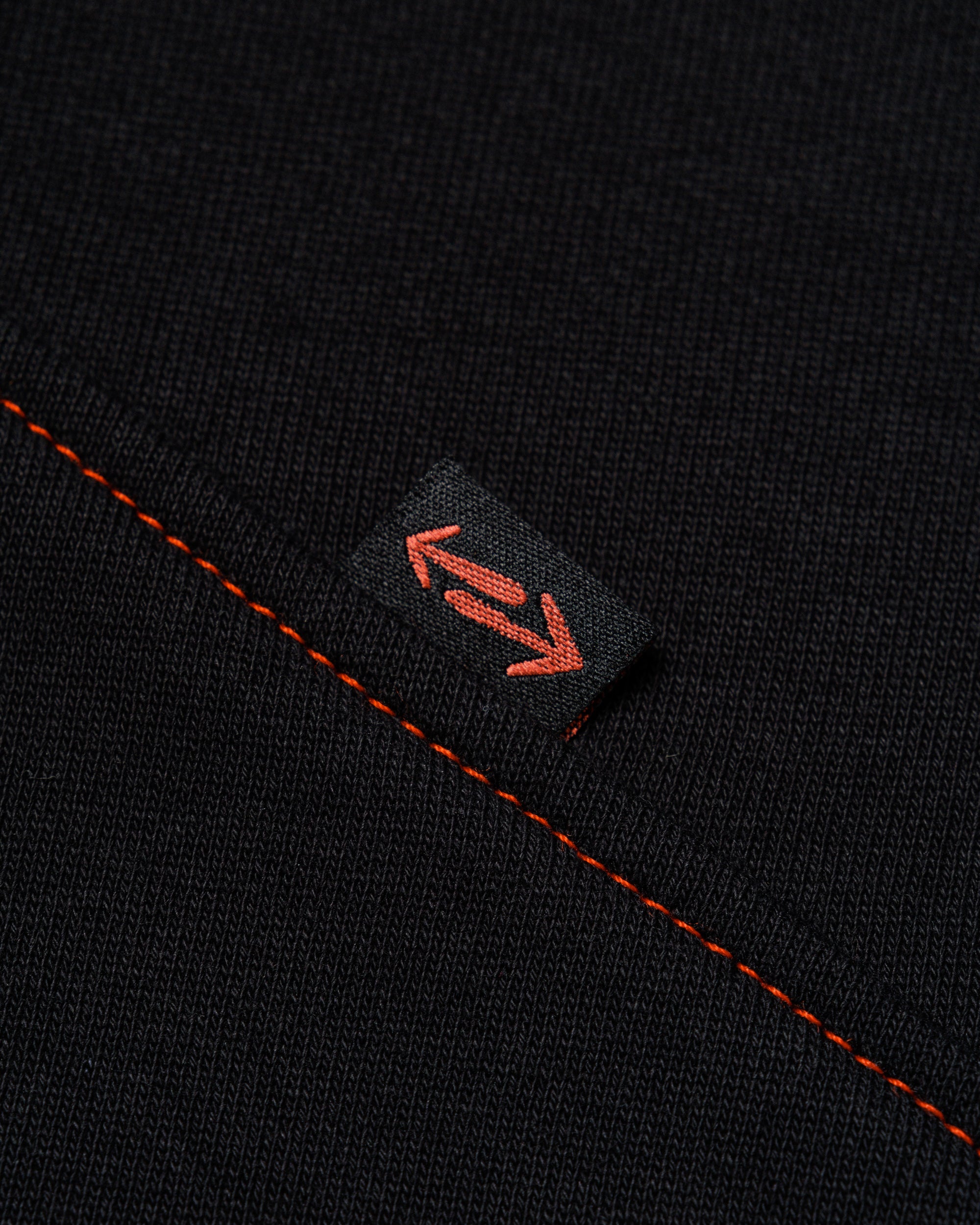 Outnback Recovery Cape in black, woven arrow tab detail
