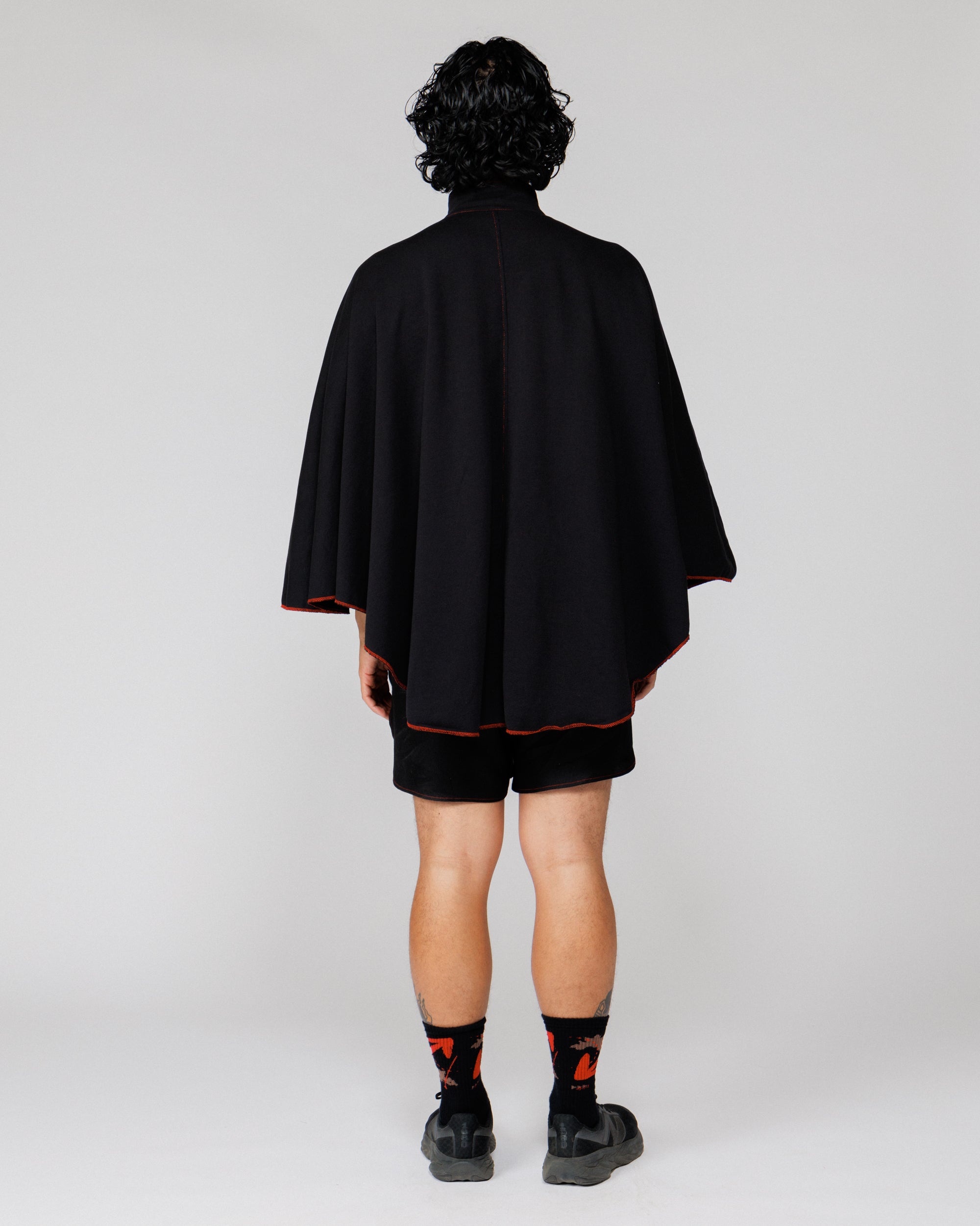 Model wearing the Outnback Recovery Cape in black, full-length back view