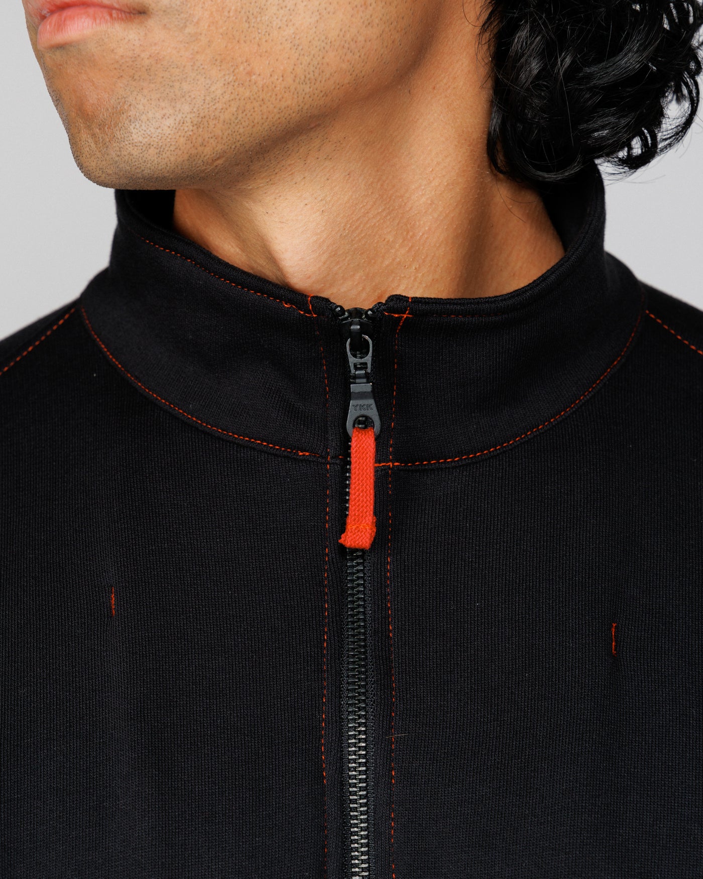 Close-up of the Outnback Recovery Cape funnel collar and zip worn by model
