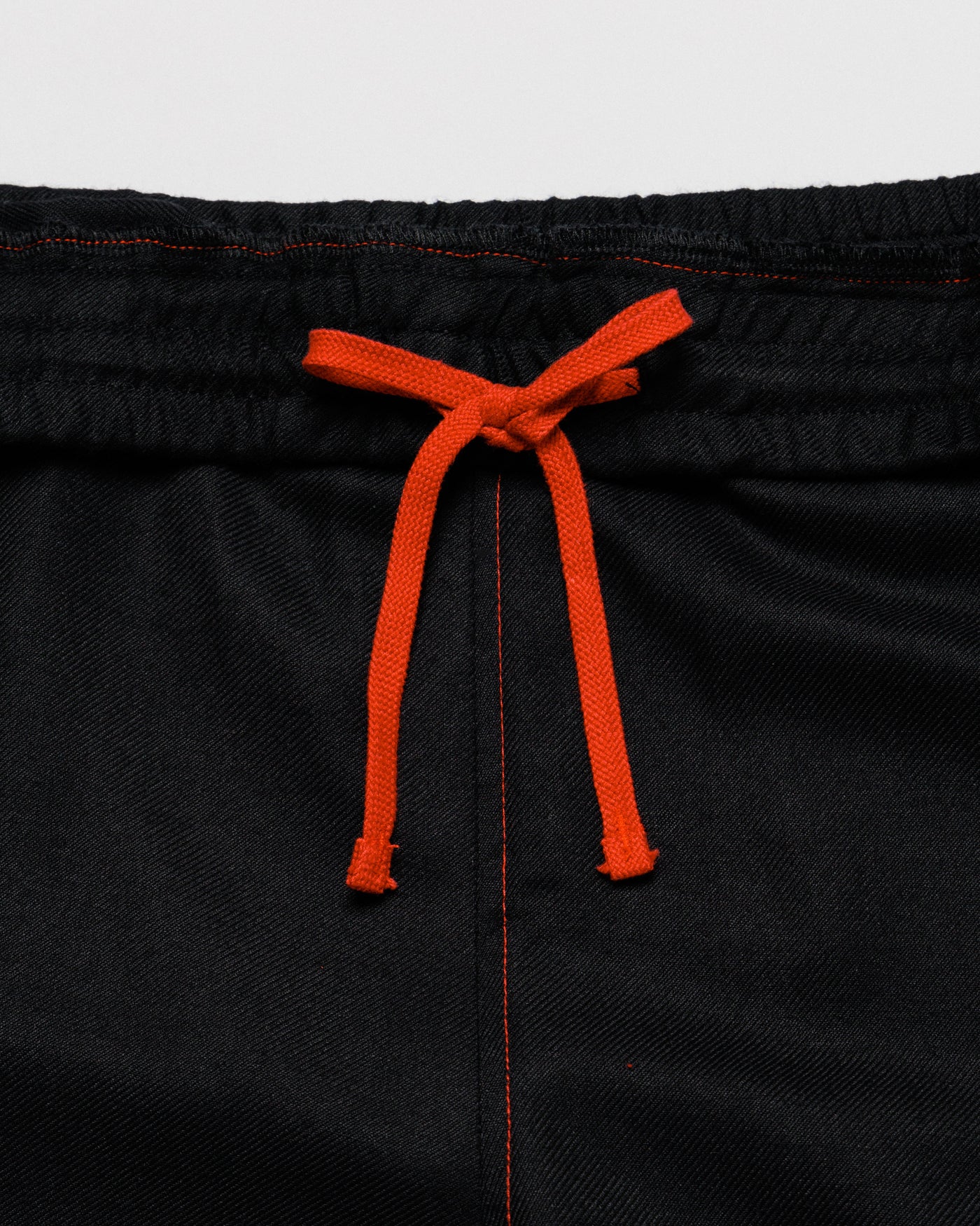 Outnback Running Short in black, waistband with orange drawcord detail