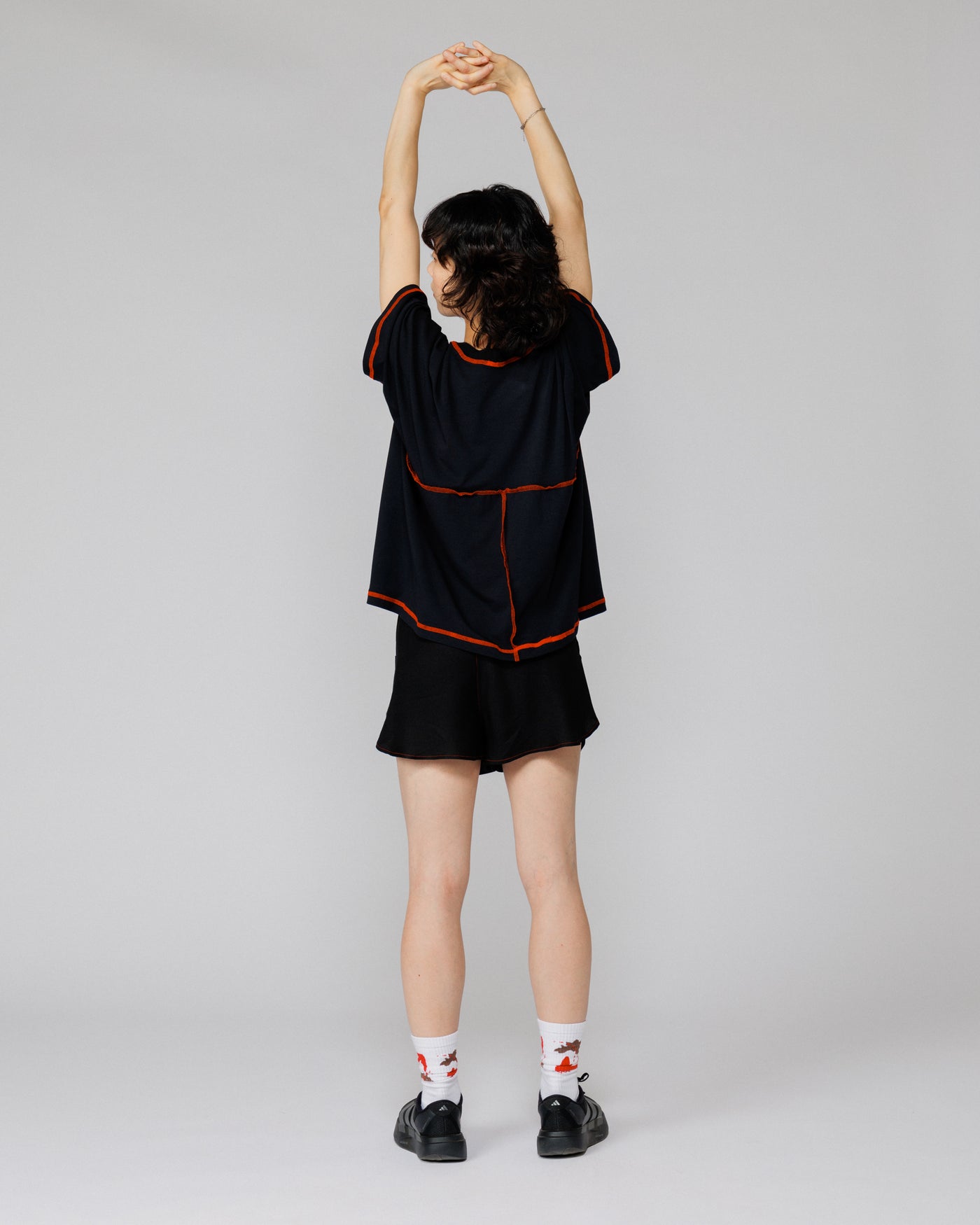 Outnback Running Short in black, back view on model mid-stretch