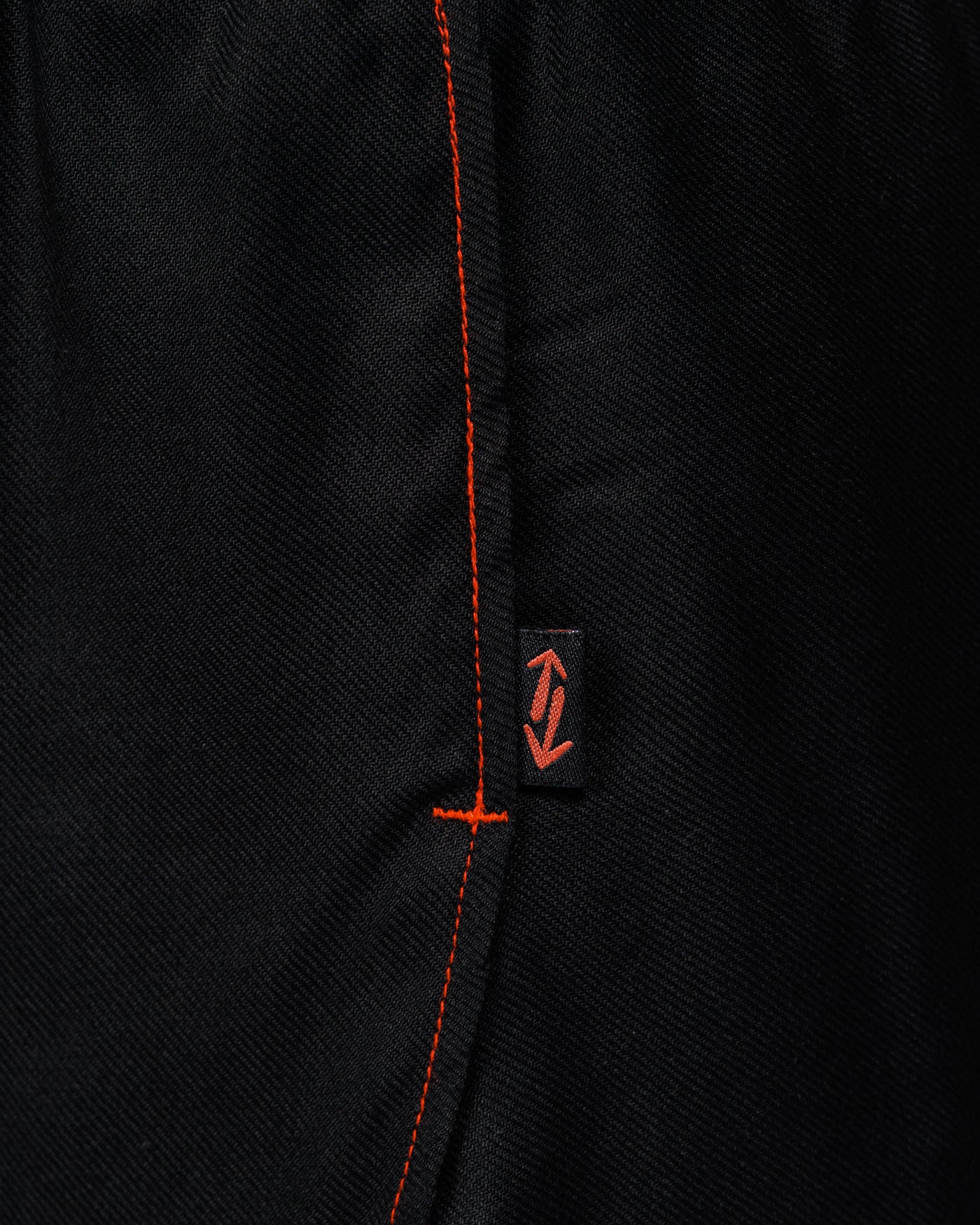 Outnback Running Short in black, macro of the woven logo tab and red contrast stitching