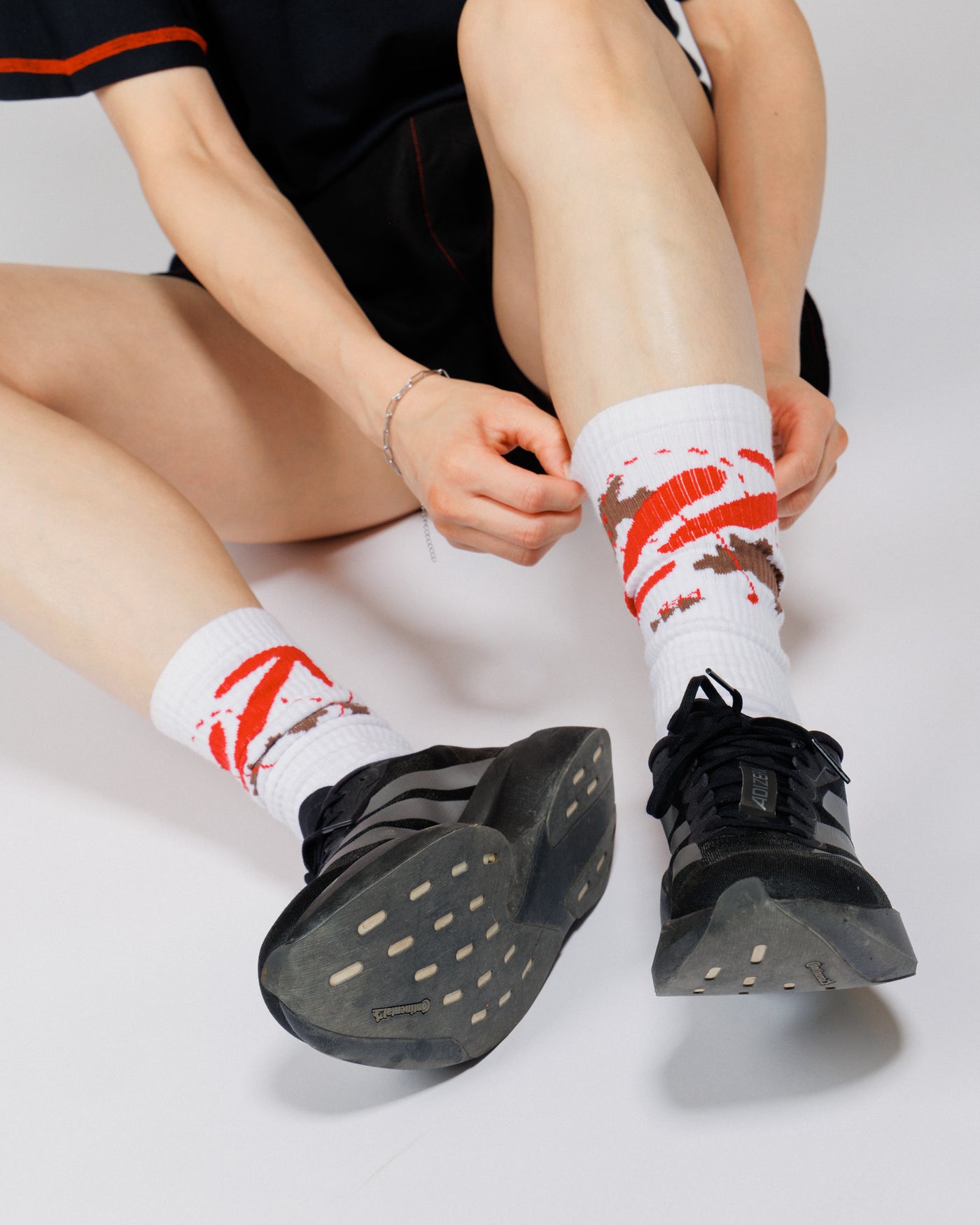 Outnback Running Socks in white and red worn on-model with running trainers