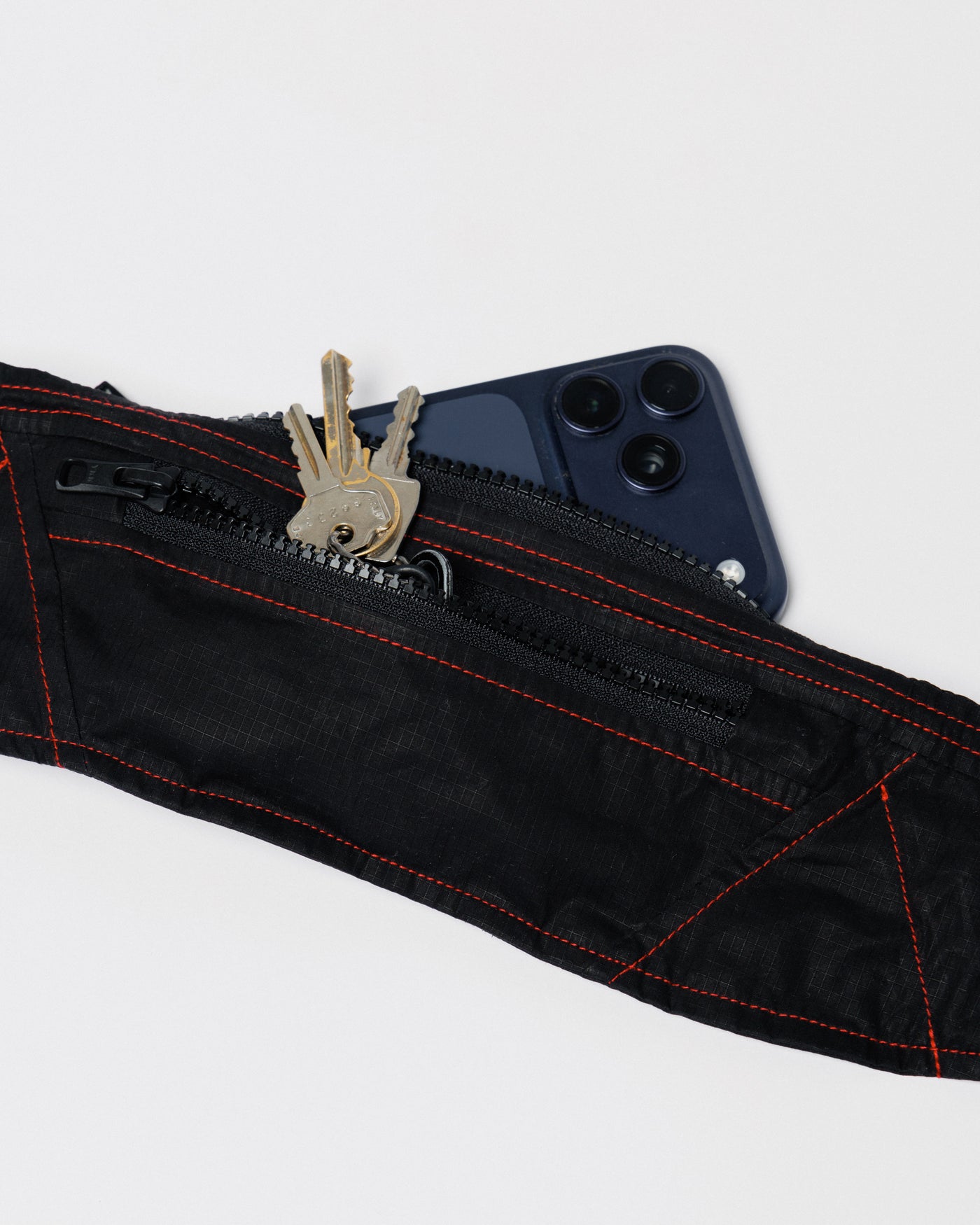 Outnback Running Strap in black, pocket holding keys and a phone