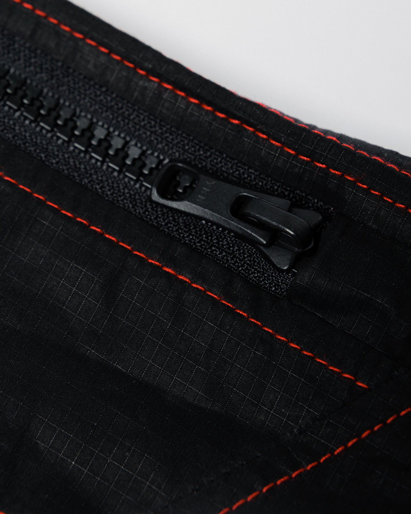 Outnback Running Strap in black, zip teeth and pull detail