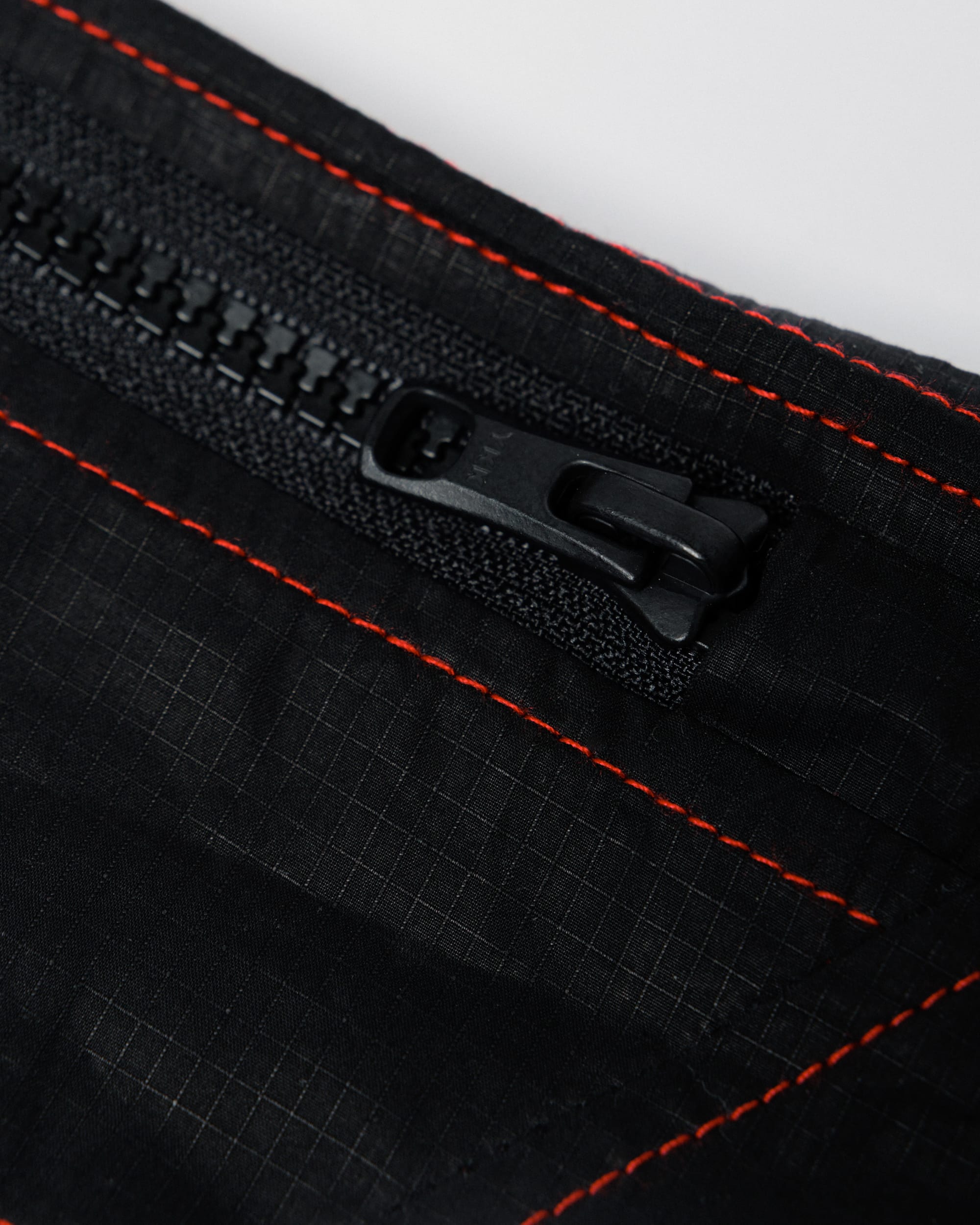 Outnback Running Strap in black, zip teeth and pull detail
