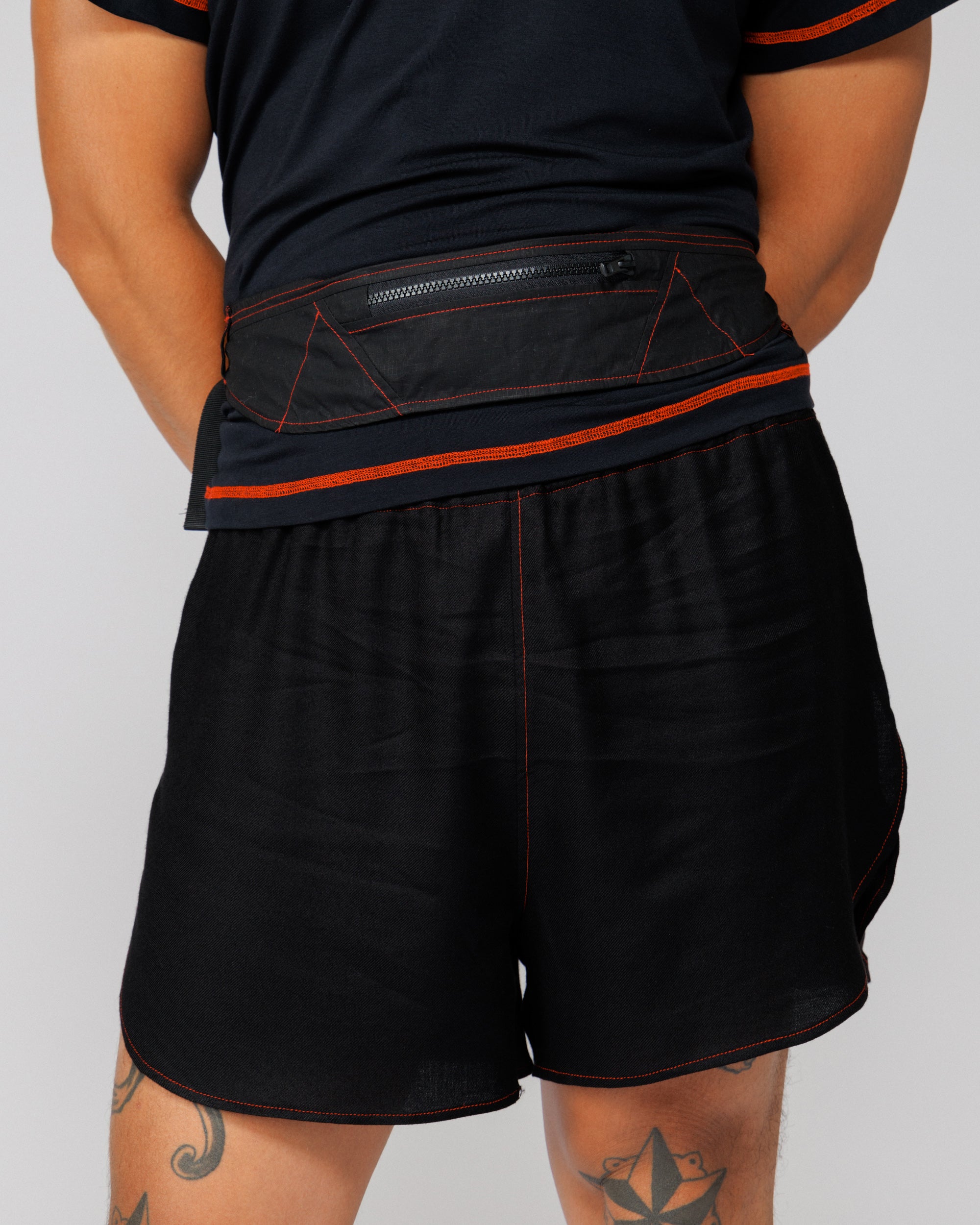 Outnback Running Strap in black worn at the waist, back view showing the rear zip pocket