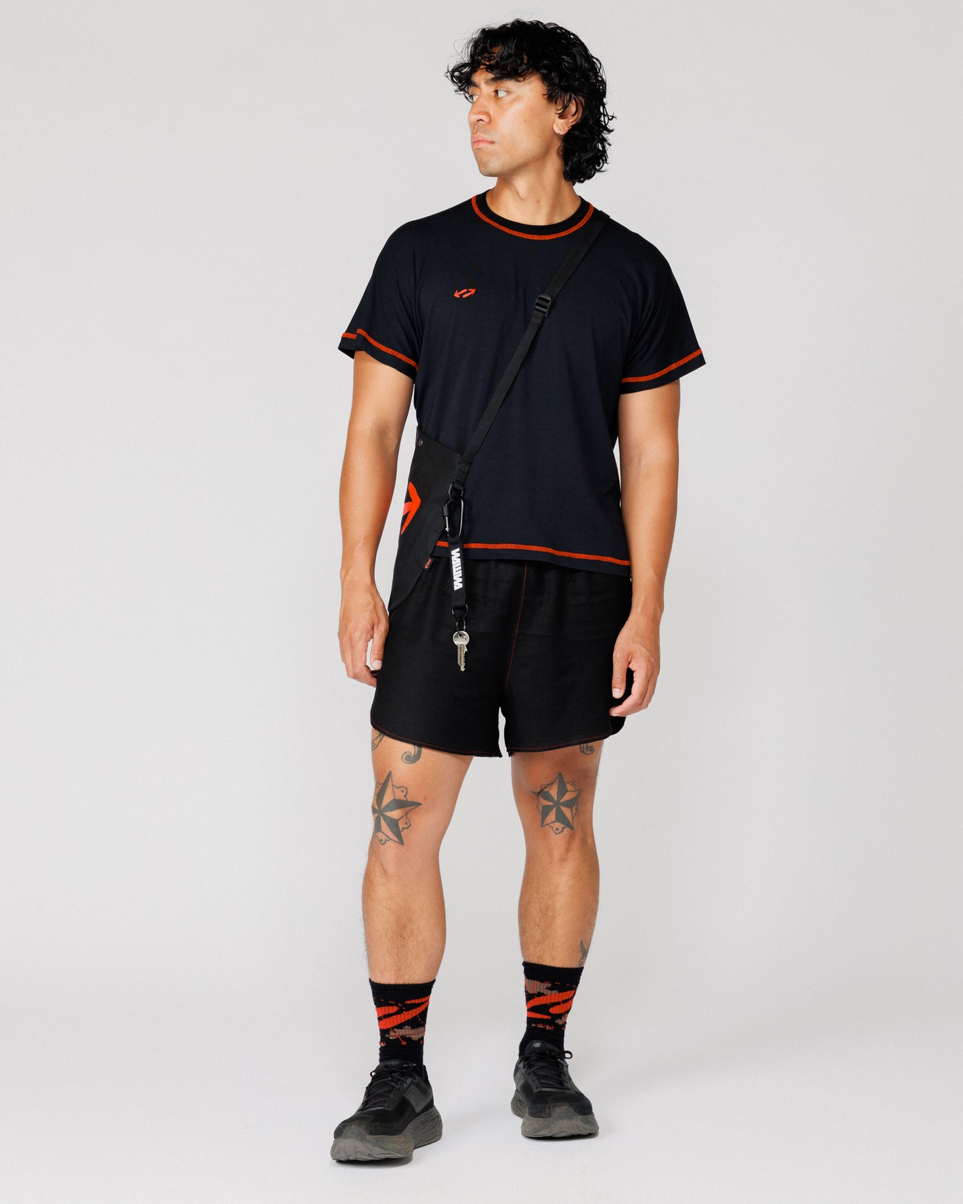 Model wearing the Outnback Running Strap in black crossbody over the shoulder with keys clipped on