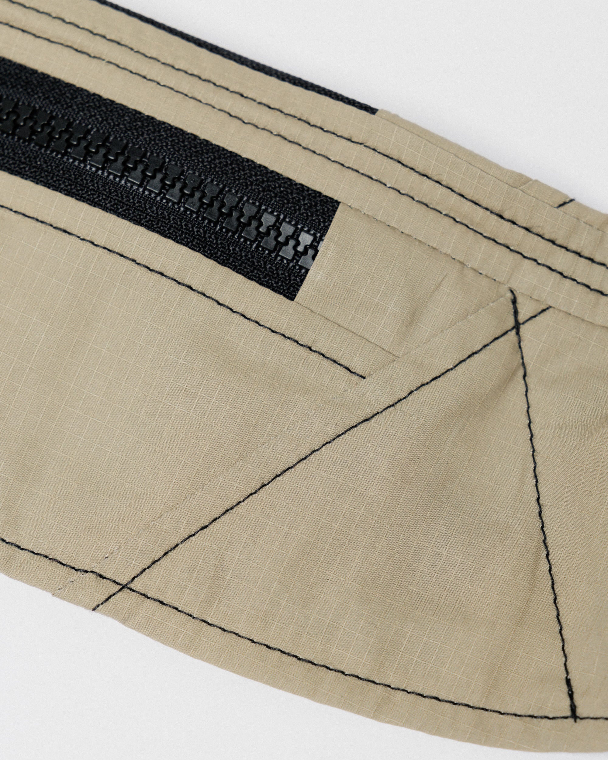 Outnback Running Strap in stone, close-up of the zip pocket and construction