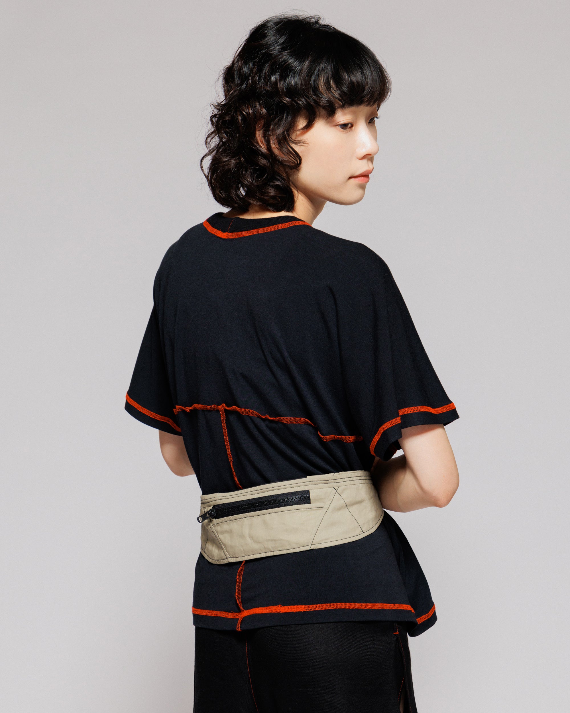 Outnback Running Strap in stone worn at the waist, back view on model