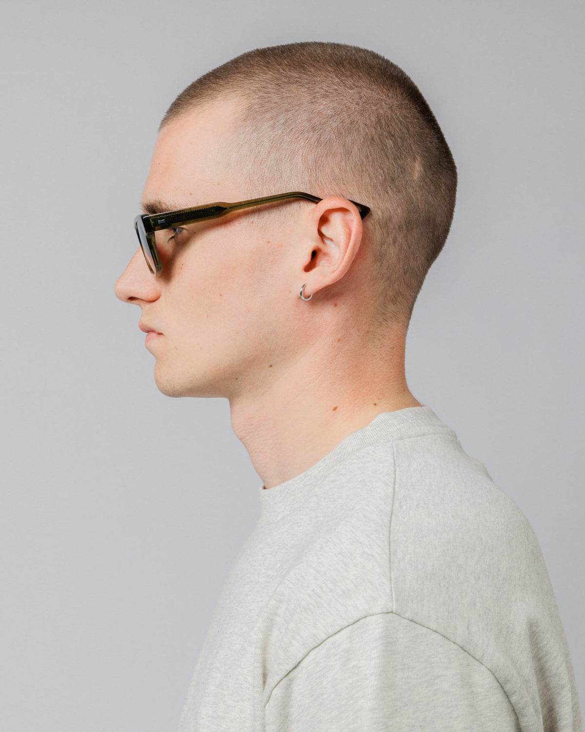 Male model wearing Solaris Sunglasses in khaki, side profile showing temple arm